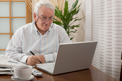 Senior man working from home with a laptop.